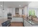 Well-equipped kitchen with stainless steel appliances, granite countertops, white cabinetry, and modern fixtures at 6509 Duncans Creek Ct, Fuquay Varina, NC 27526