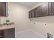 A laundry room with tile floor and dark cabinets at 6509 Duncans Creek Ct, Fuquay Varina, NC 27526