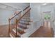 Beautiful staircase with dark iron spindles, wooden banister, and hardwood floors at 6509 Duncans Creek Ct, Fuquay Varina, NC 27526