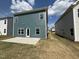Home exterior featuring blue siding, multiple windows, and concrete patio at 67 Commons Cir, Clayton, NC 27520