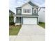 Inviting two-story home with blue siding, white trim, shuttered windows, and a two-car garage at 67 Commons Cir, Clayton, NC 27520