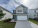 Charming two-story home with a two-car garage, concrete driveway, and manicured lawn at 67 Commons Cir, Clayton, NC 27520
