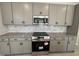 Modern kitchen with stainless steel appliances, gray cabinets, and granite countertops at 67 Commons Cir, Clayton, NC 27520