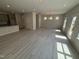 Open-concept living room with light, wood-look flooring and plentiful natural light, perfect for entertaining at 67 Commons Cir, Clayton, NC 27520
