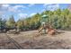 Neighborhood playground featuring a slide, picnic table and wooded backdrop at 67 Commons Cir, Clayton, NC 27520