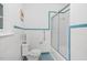 Bathroom with white tile, blue trim, toilet, grab bar, and a glass door shower at 701 E Nash St, Spring Hope, NC 27882