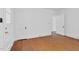 Classic bedroom featuring hardwood floors, white walls, and a door leading to other parts of the home at 701 E Nash St, Spring Hope, NC 27882