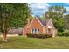 Charming brick home with lush landscaping, a manicured lawn, and mature trees offering great curb appeal at 701 E Nash St, Spring Hope, NC 27882