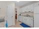 Functional kitchen features white cabinets and appliances, plus durable tile flooring at 704 Benchmark Dr, Raleigh, NC 27615