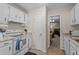 Bright kitchen with white cabinets and modern appliances, next to living area at 704 Benchmark Dr, Raleigh, NC 27615