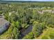 Aerial view showcases homes amongst lush trees, complete with serene pond at 711 Providence Glen Dr, Chapel Hill, NC 27514