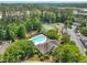 Aerial shot of a neighborhood pool, tennis courts, and clubhouse surrounded by trees at 711 Providence Glen Dr, Chapel Hill, NC 27514