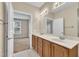 Bathroom with double sinks, wooden cabinets, and access to the bedroom at 711 Providence Glen Dr, Chapel Hill, NC 27514