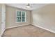 The simple bedroom has a ceiling fan, neutral walls and carpeting, and one window, making for a blank canvas at 711 Providence Glen Dr, Chapel Hill, NC 27514