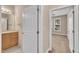 View of a hallway with door and bathroom vanity leading to a bedroom with large windows at 711 Providence Glen Dr, Chapel Hill, NC 27514