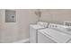 Functional laundry room featuring a white washer and dryer, a wire rack, and a neutral colored wall at 711 Providence Glen Dr, Chapel Hill, NC 27514