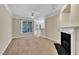 Bright living room featuring large window, fireplace, ceiling fan, and neutral carpet at 711 Providence Glen Dr, Chapel Hill, NC 27514