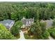 An aerial view shows a gorgeous home surrounded by lush green trees and landscaping at 74002 Harvey, Chapel Hill, NC 27517