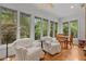 Bright sunroom with large windows, comfortable seating, and hardwood floors at 74002 Harvey, Chapel Hill, NC 27517