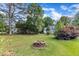 Backyard features a brick fire pit and distant view of the rear exterior of the home at 8113 Huskfield Ct, Apex, NC 27539