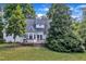 View of the rear exterior of the home shows a deck and beautiful mature trees at 8113 Huskfield Ct, Apex, NC 27539