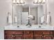 Bathroom featuring a double sink vanity, large mirror, and decorative accents at 8113 Huskfield Ct, Apex, NC 27539