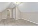 Beige carpeted bedroom shows sloped ceiling with access to hall and attic access at 8113 Huskfield Ct, Apex, NC 27539