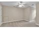 A large beige carpeted bedroom with a door to an attic access at 8113 Huskfield Ct, Apex, NC 27539