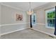 Elegant dining room with a chandelier, neutral walls, and large windows at 8113 Huskfield Ct, Apex, NC 27539