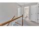 Upstairs hallway with staircase and views into an adjacent bathroom at 8113 Huskfield Ct, Apex, NC 27539