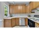 Efficient kitchen with wooden cabinets, stainless steel dishwasher, and countertop space at 8113 Huskfield Ct, Apex, NC 27539