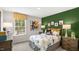 Colorful bedroom featuring full-size bed, green accent wall, and bright natural light at 816 Bullhorn Dr, Wake Forest, NC 27587
