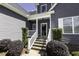 Charming front entrance with gray siding, a covered porch, and manicured landscaping at 870 Live Oak Ln, Nashville, NC 27856