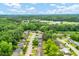 An aerial view of a cozy neighborhood with houses nestled among lush, green trees under a blue sky at 1007 Ancroft Ave, Durham, NC 27713