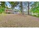 A view of the backyard showing the wooden deck and a shed amidst a green, tree-filled landscape at 1007 Ancroft Ave, Durham, NC 27713