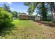 Back of a house featuring a deck, shed, and spacious green yard with mature trees and blue sky at 1007 Ancroft Ave, Durham, NC 27713