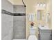 Cozy bathroom features a tiled shower with decorative accents, vanity, and toilet at 1007 Ancroft Ave, Durham, NC 27713