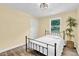 Simple bedroom featuring wood-look vinyl floors, a window, and a decorative houseplant at 1007 Ancroft Ave, Durham, NC 27713