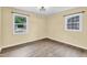 Empty bedroom with wood-look vinyl flooring, two windows, and freshly painted walls at 1007 Ancroft Ave, Durham, NC 27713