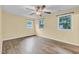 Spacious bedroom featuring wood-look flooring, neutral paint, ceiling fan, and bright windows at 1007 Ancroft Ave, Durham, NC 27713