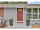 Close-up of a red front door framed by planters and decorative sidelight at 1007 Ancroft Ave, Durham, NC 27713