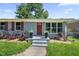 Inviting home exterior featuring a red front door, fresh landscaping, and a neatly kept lawn at 1007 Ancroft Ave, Durham, NC 27713