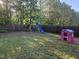 Expansive backyard with play set, a playhouse and lush greenery, ideal for outdoor fun at 1030 Thoughtful Spot Ln, Durham, NC 27703