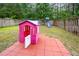 Charming backyard featuring a pink playhouse, swing set, and privacy fence surrounded by lush greenery at 1030 Thoughtful Spot Ln, Durham, NC 27703