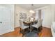 Well-lit dining room featuring a wooden table, fabric chairs, chandelier, and hardwood flooring at 1030 Thoughtful Spot Ln, Durham, NC 27703