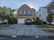Charming two-story home with a gray brick exterior, attached two-car garage, and well-maintained lawn at 1030 Thoughtful Spot Ln, Durham, NC 27703