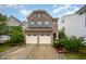 Charming two-story brick home featuring a two-car garage, manicured landscaping, and a welcoming front entrance at 1030 Thoughtful Spot Ln, Durham, NC 27703
