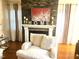 Close-up of the fireplace with stone accents and a white mantel, accented with decorative items and soft lighting at 1030 Thoughtful Spot Ln, Durham, NC 27703
