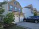 View of the garage with a two-car door, brick facade, and car parked in the driveway at 1030 Thoughtful Spot Ln, Durham, NC 27703