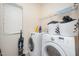 Bright laundry room featuring a washer and dryer set, shelving, and a window with blinds at 1030 Thoughtful Spot Ln, Durham, NC 27703